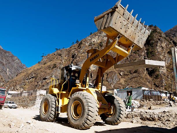 Zhangmu, China - December 7, 2007: Construction workers work with excavators on a project to improve the road between Tibet and Nepal, known as the friendship highway near Zhangmu on the border between China and Nepal.